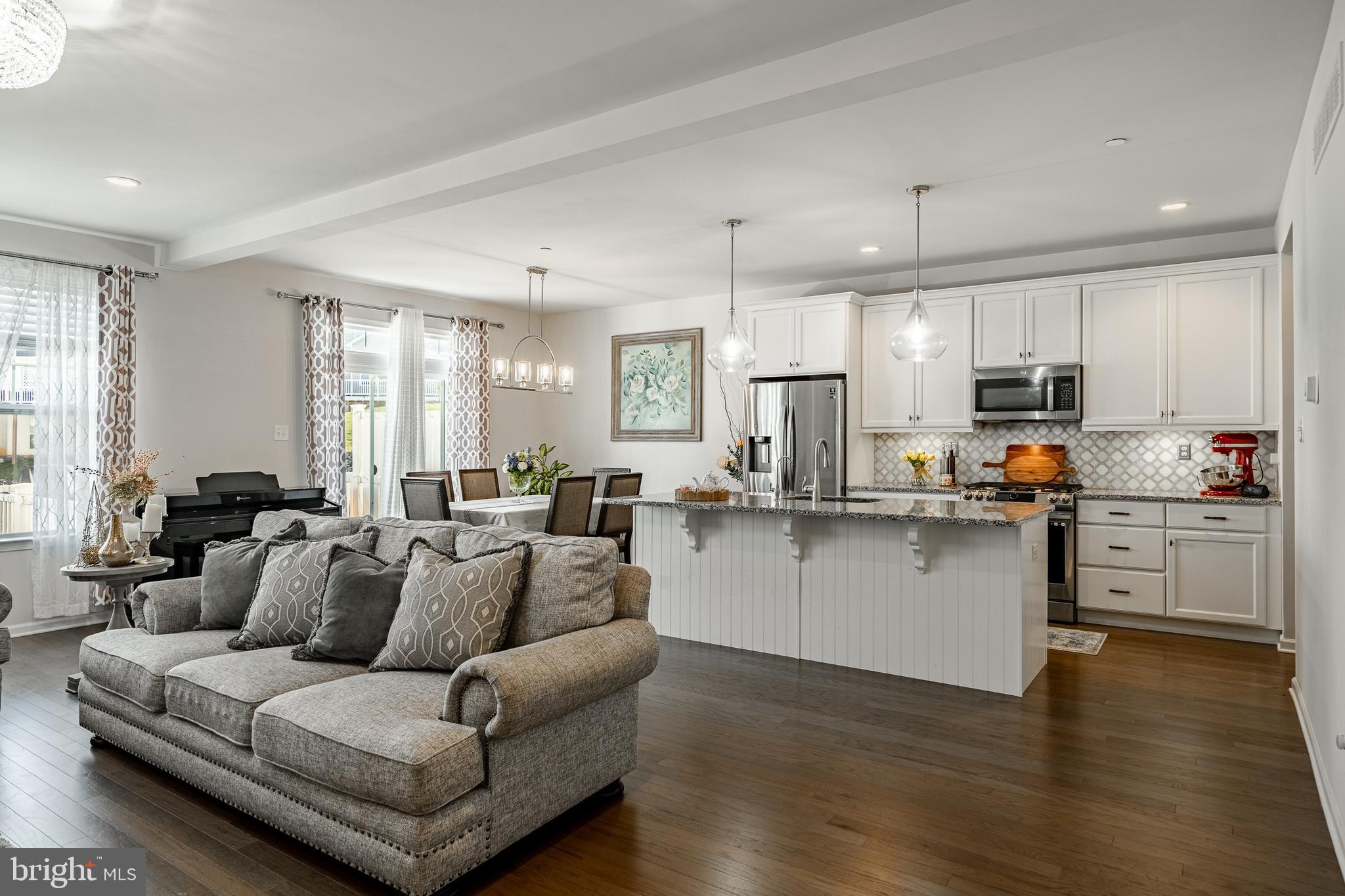 25 North Tompkins Square Downingtown, PA 19335 - Photo 6 of 53 a living room with stainless steel appliances kitchen island granite countertop a couch and white cabinets