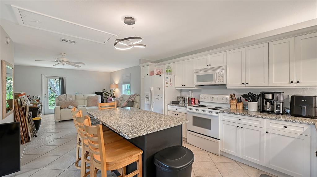 3012 Desoto Road Sarasota, FL 34234 - Photo 62 of 78 a kitchen with a stove a sink dishwasher a dining table and chairs with wooden floor