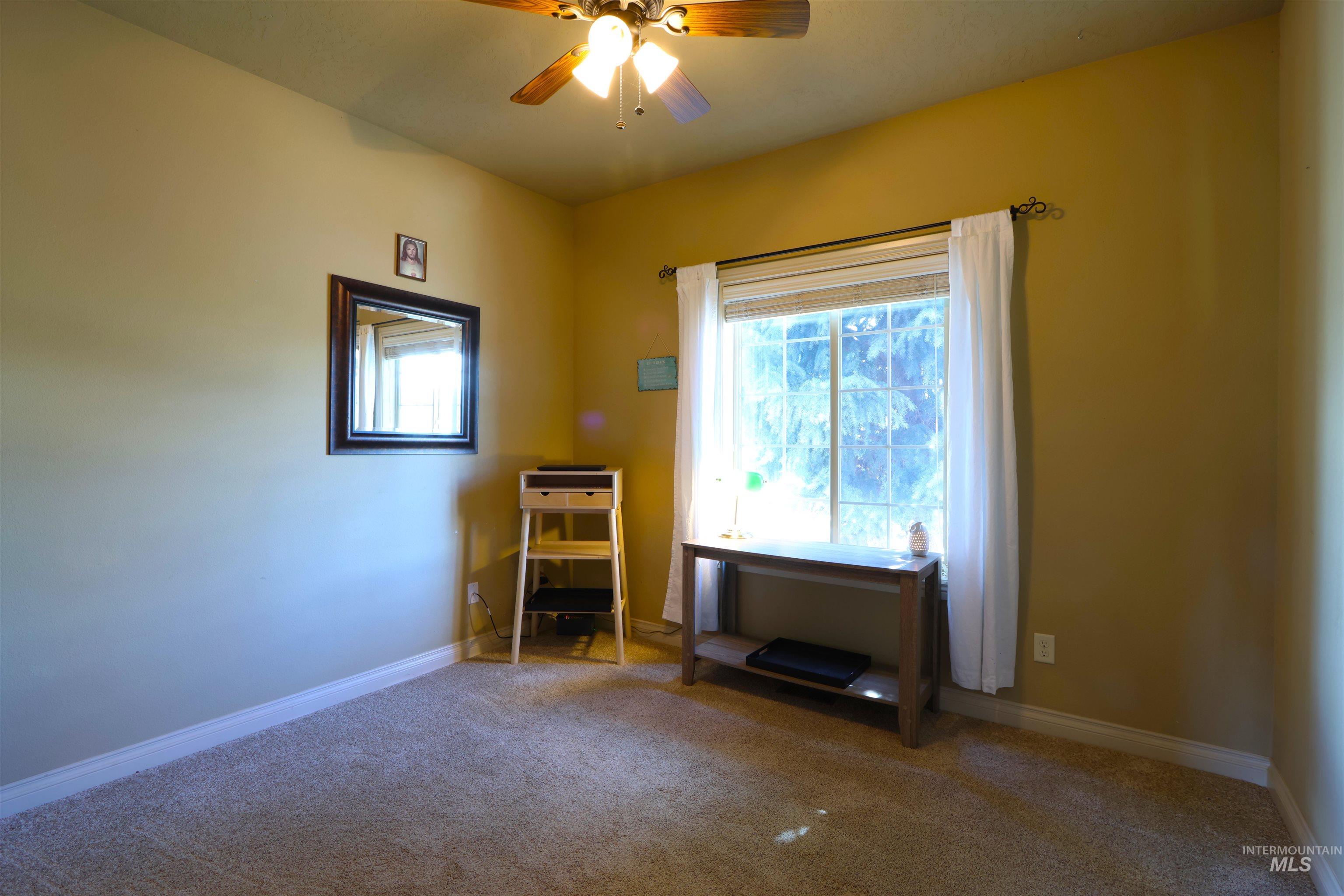 2278 Golf Lane Council, ID 83612 - Photo 15 of 31 Carpeted room featuring a ceiling fan with integrated lighting, a window with white blinds and sheer curtains, and light-toned wall paint