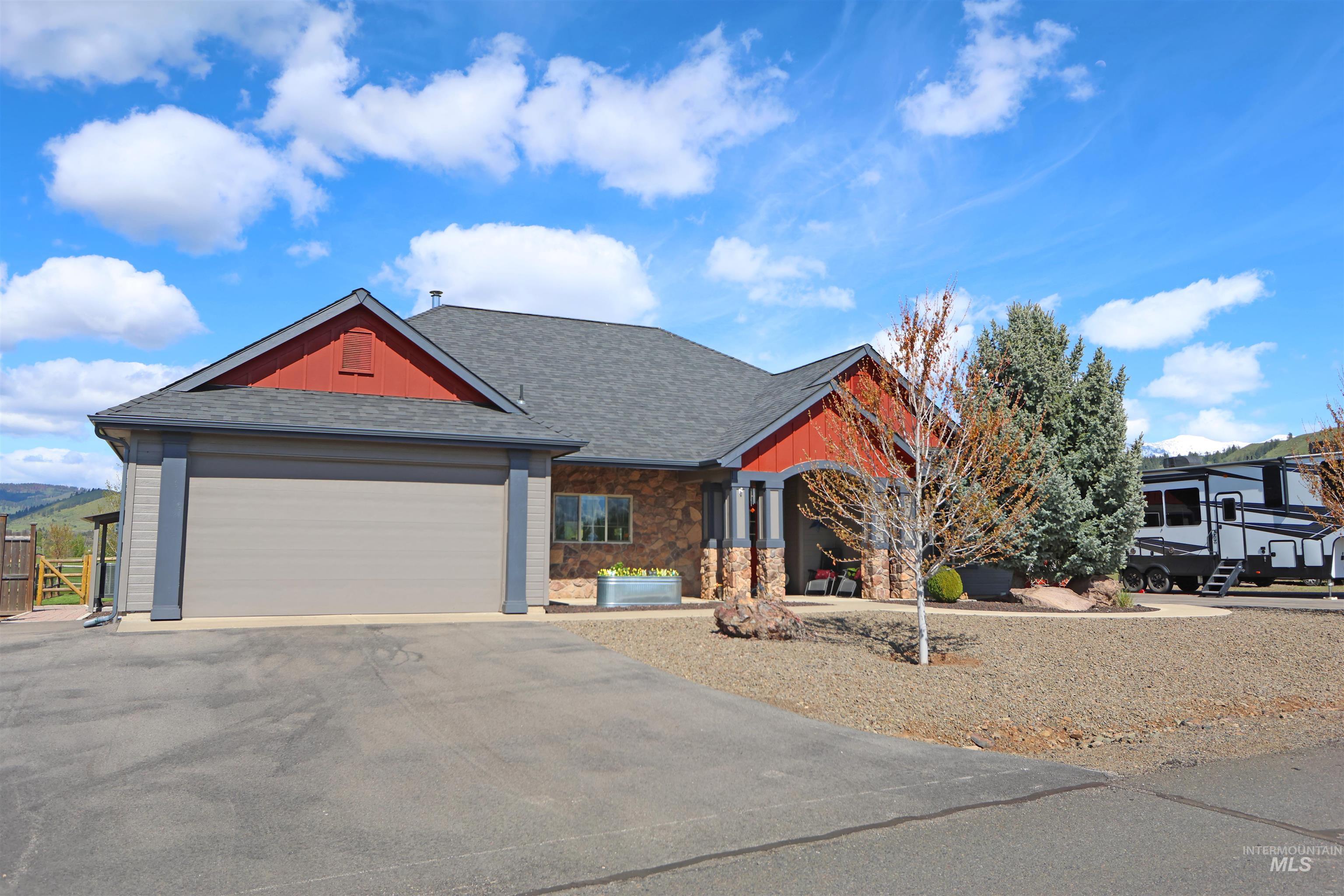 2278 Golf Lane Council, ID 83612 - Photo 30 of 31 Contemporary-style residence featuring a two-car garage, stone and siding exterior, covered entry, mature landscaping, and a paved driveway