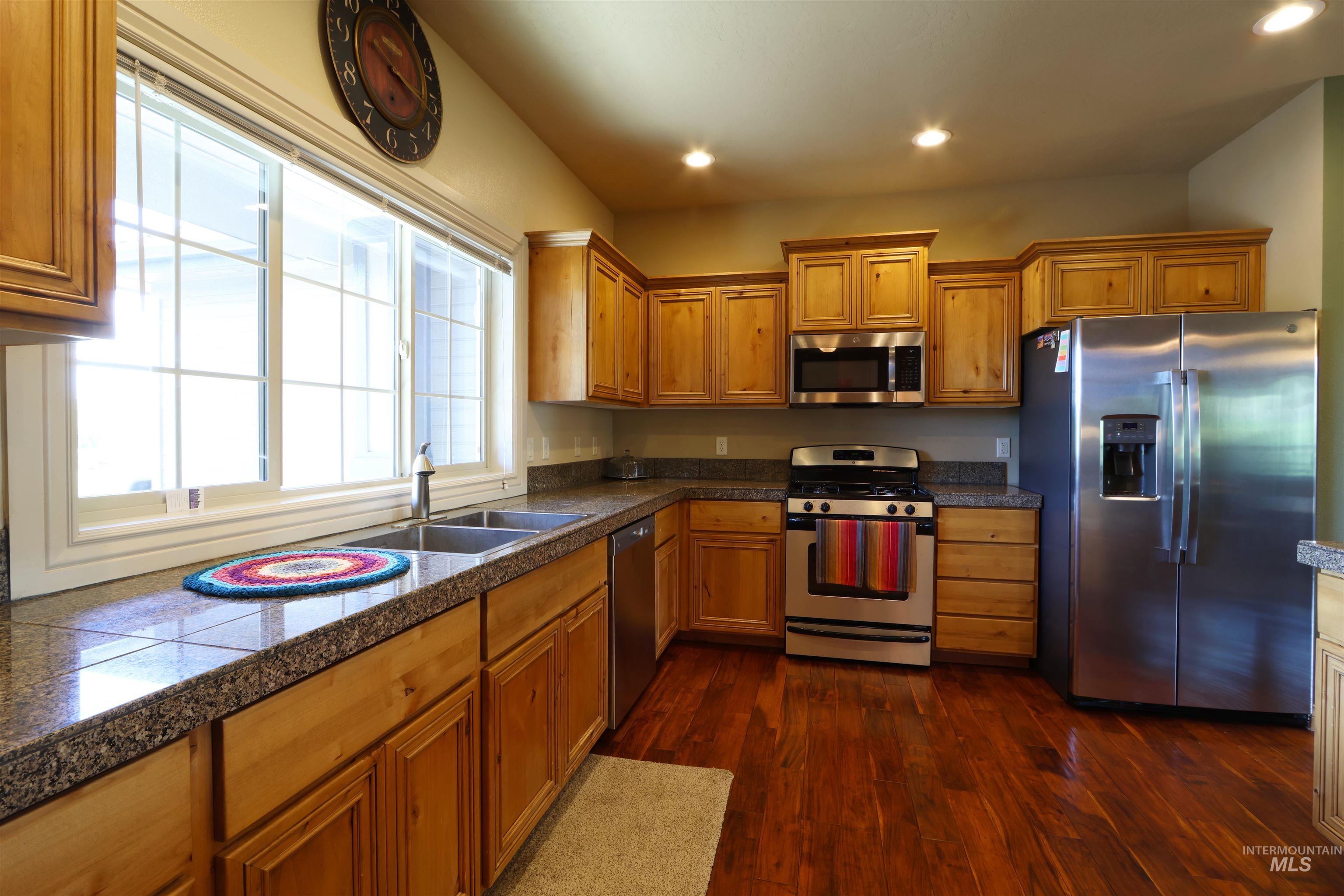 2278 Golf Lane Council, ID 83612 - Photo 7 of 31 Kitchen featuring wood-finish flooring, light wood cabinetry, stone countertops, and a stainless steel appliance suite