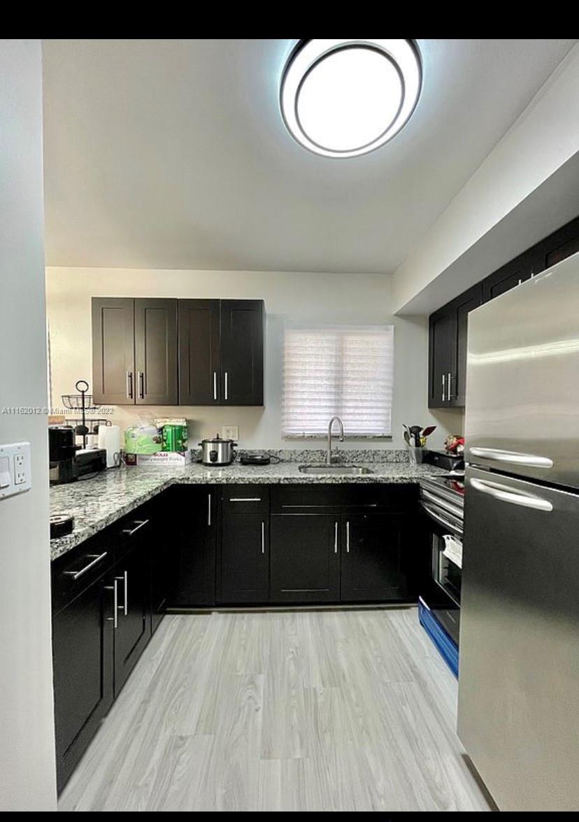 Kendale Lakes Miami, FL 33183 - Photo 1 of 9 a large kitchen with granite countertop a stove top oven a sink dishwasher and white cabinets with wooden floor