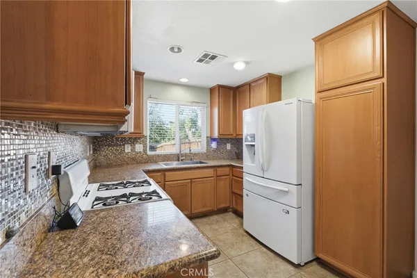 a kitchen with a refrigerator a stove a sink dishwasher and cabinets