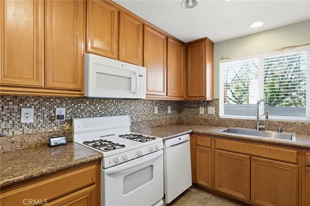 a kitchen with stainless steel appliances granite countertop a sink a stove and cabinets