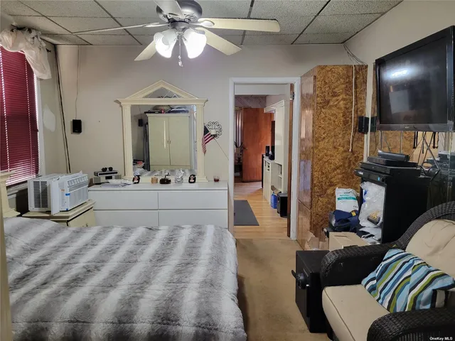 a spacious bedroom with a bed a chandelier and a flat screen tv