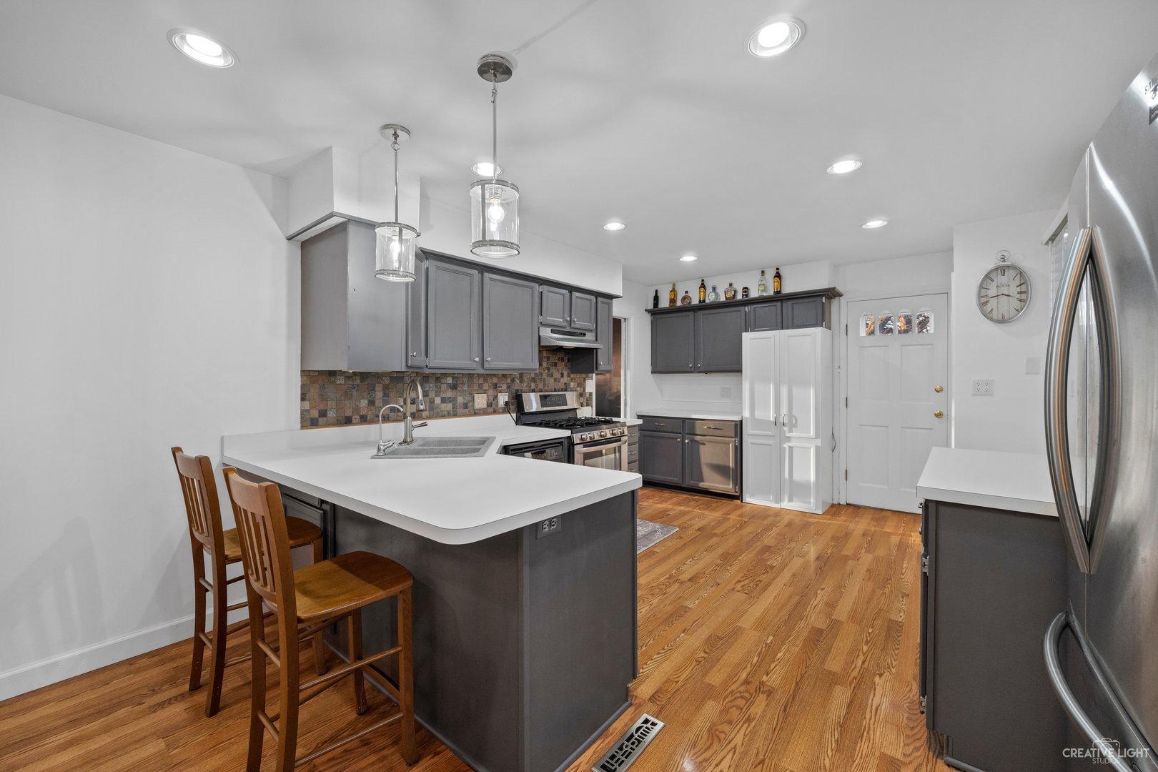 4S064 Thornapple Tree Road Sugar Grove, IL 60554 - Photo 7 of 39 a kitchen with stainless steel appliances a table chairs wooden floors and a view of living room