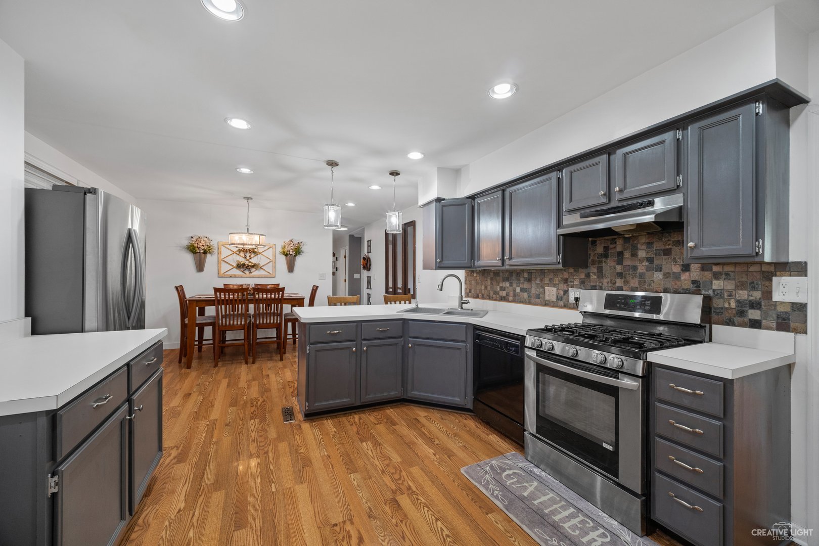 4S064 Thornapple Tree Road Sugar Grove, IL 60554 - Photo 8 of 39 a kitchen with stainless steel appliances granite countertop a stove top oven a sink dishwasher a dining table and chairs with wooden floor