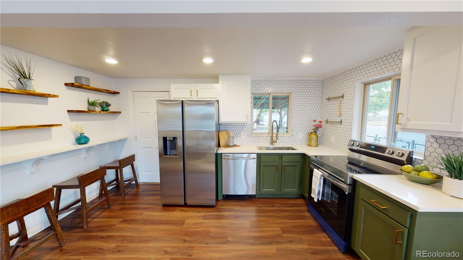 a kitchen with stainless steel appliances granite countertop a sink a stove a refrigerator cabinets and a window