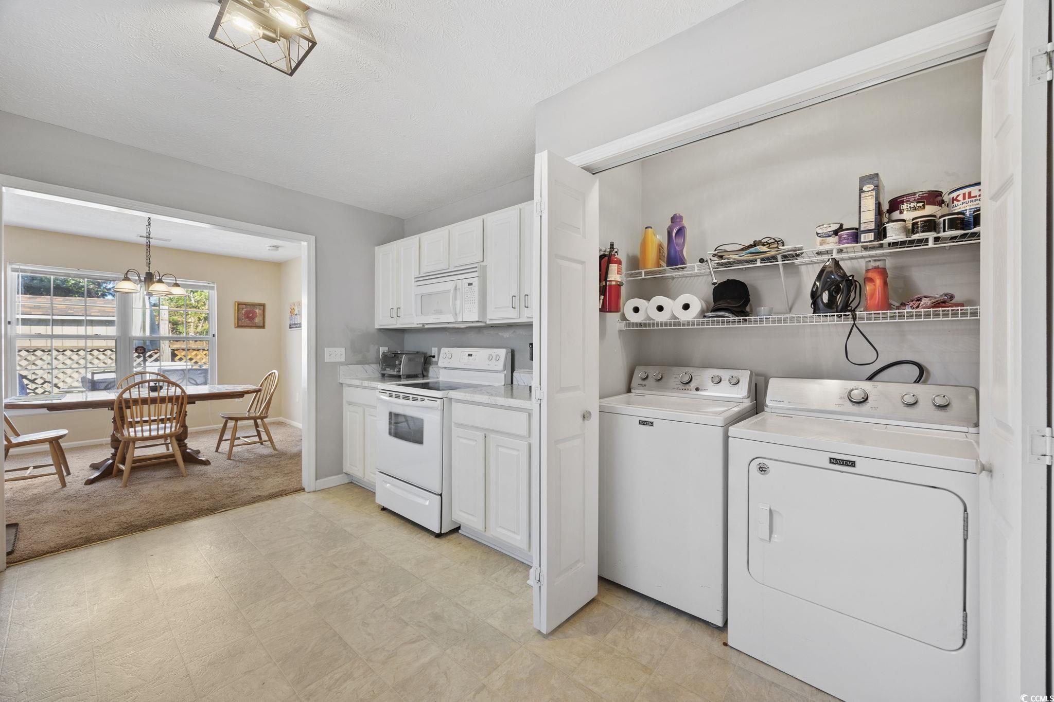 2902 Silverleaf Circle Loris, SC 29569 - Photo 12 of 38 Kitchen with white appliances, light countertops, white cabinets, a chandelier, and washing machine and dryer
