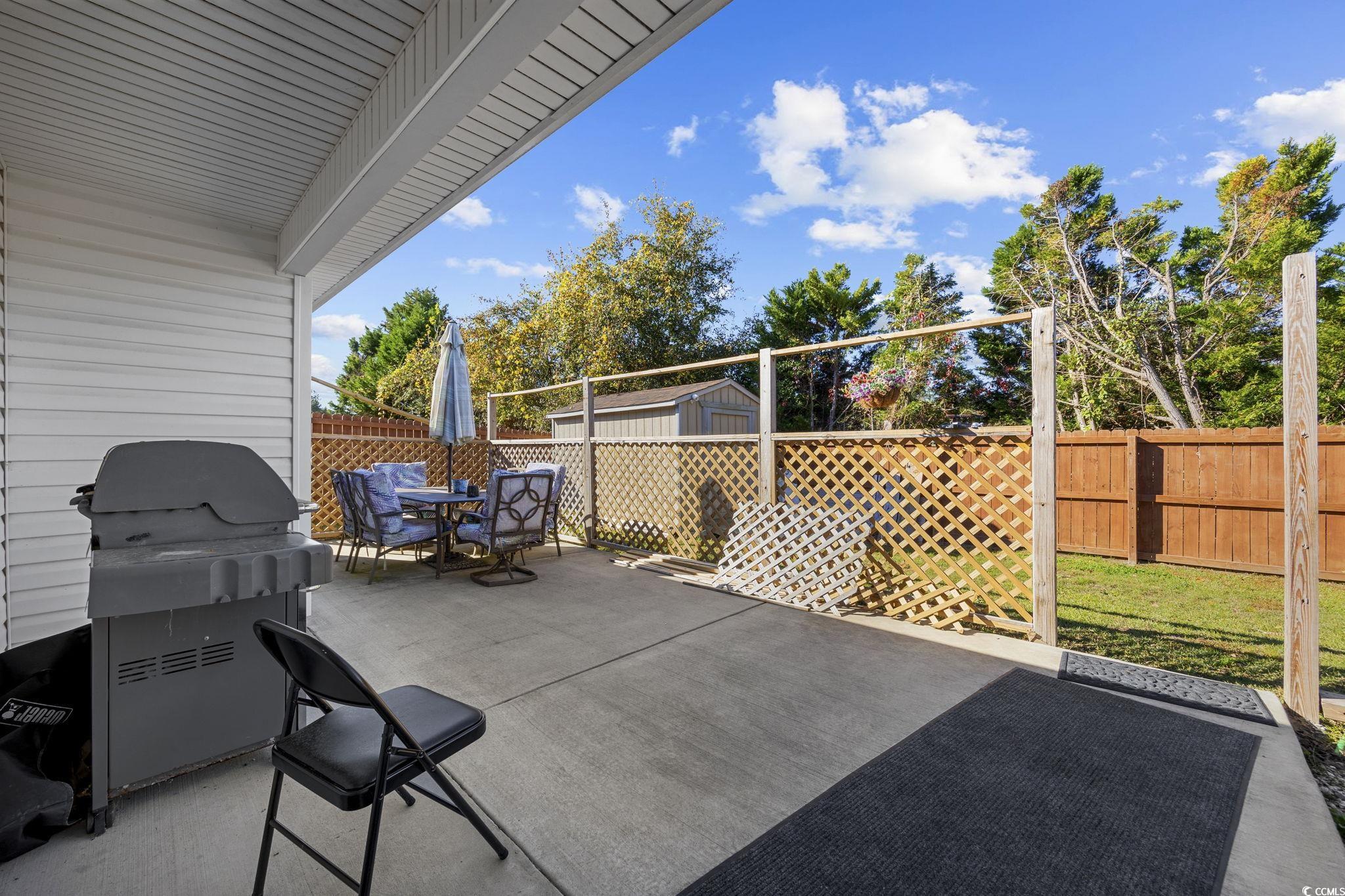2902 Silverleaf Circle Loris, SC 29569 - Photo 24 of 38 Fenced backyard with a patio area, a grill, outdoor dining area, and an outdoor structure