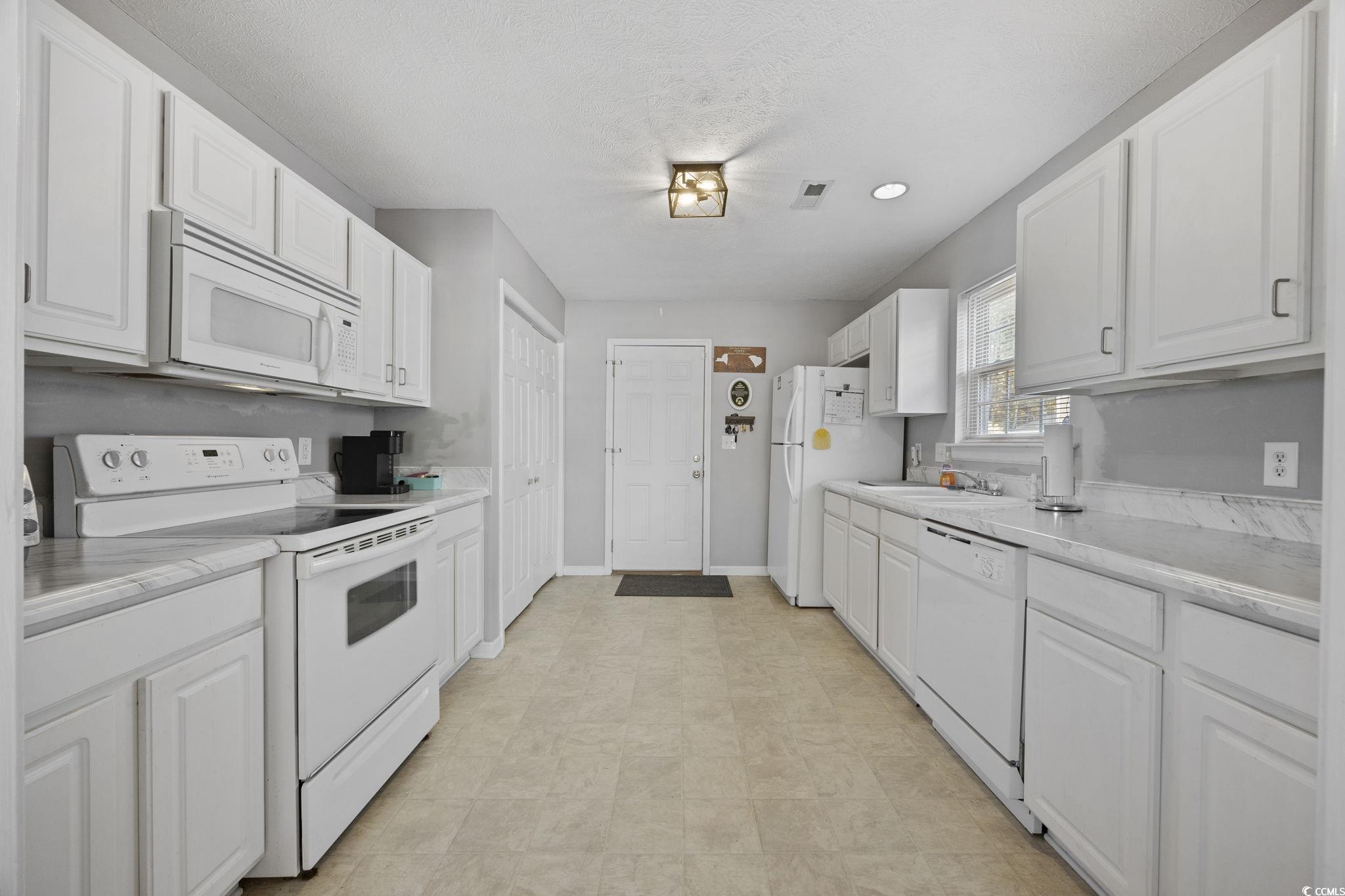 2902 Silverleaf Circle Loris, SC 29569 - Photo 8 of 38 Kitchen featuring white appliances, white cabinetry, a textured ceiling, and recessed lighting