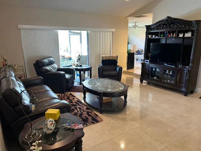 a living room with furniture a flat screen tv and a window