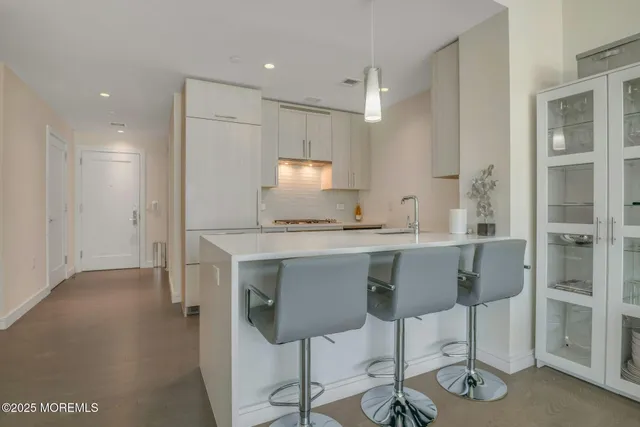 a kitchen with granite countertop cabinets and chair
