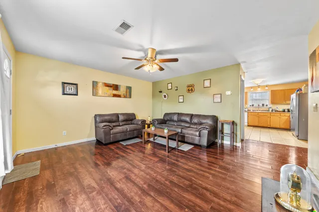 a living room with furniture and a wooden floor