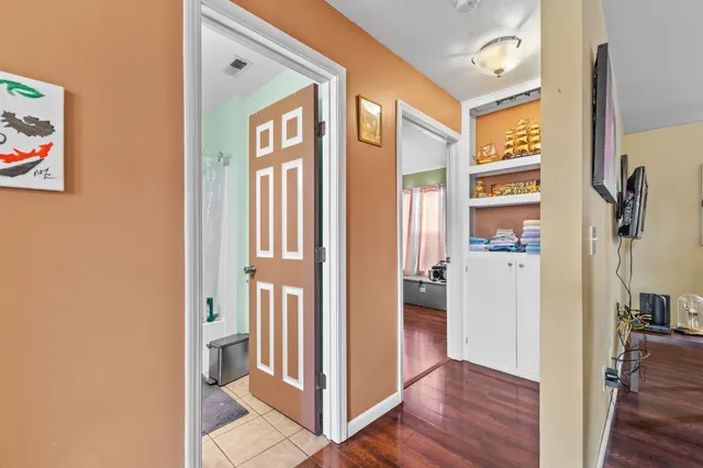a view of a hallway with wooden floor and closet