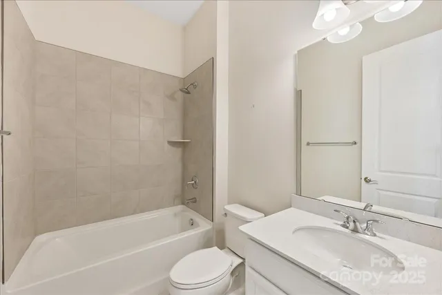 a bathroom with a granite countertop sink a toilet and bathtub