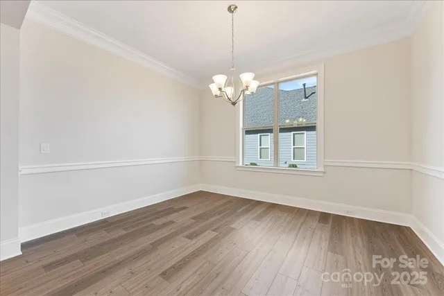 a view of a room with wooden floor and chandelier