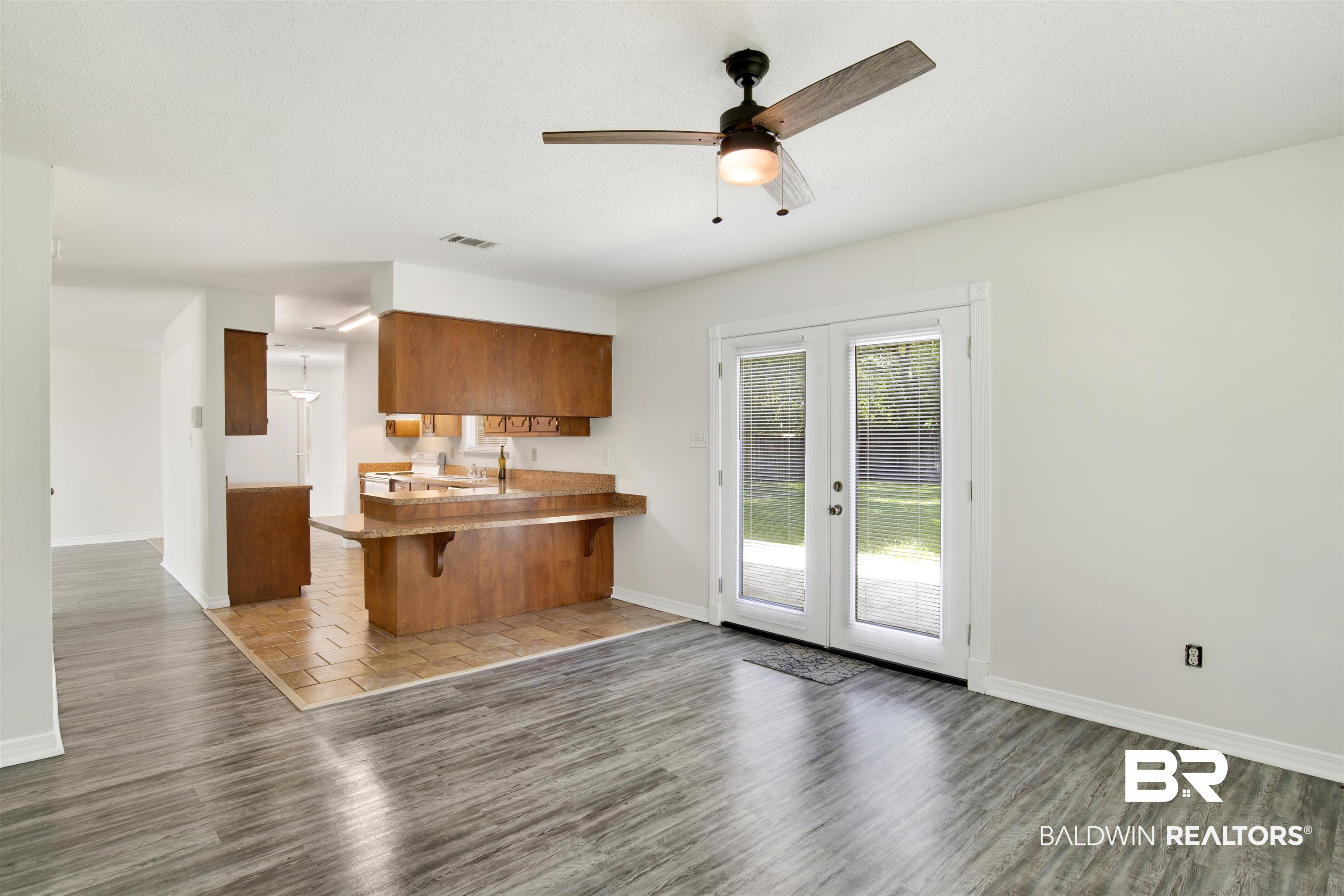 5480 Country Club Boulevard Theodore, AL 36582 - Photo 15 of 36 Kitchen featuring sink, wood-type flooring, kitchen peninsula, ceiling fan, and a kitchen bar