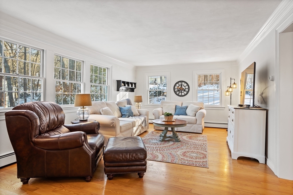 84 Vaughn Hill Road Bolton, MA 01740 - Photo 12 of 40 a living room with furniture floor to ceiling window and wooden floor