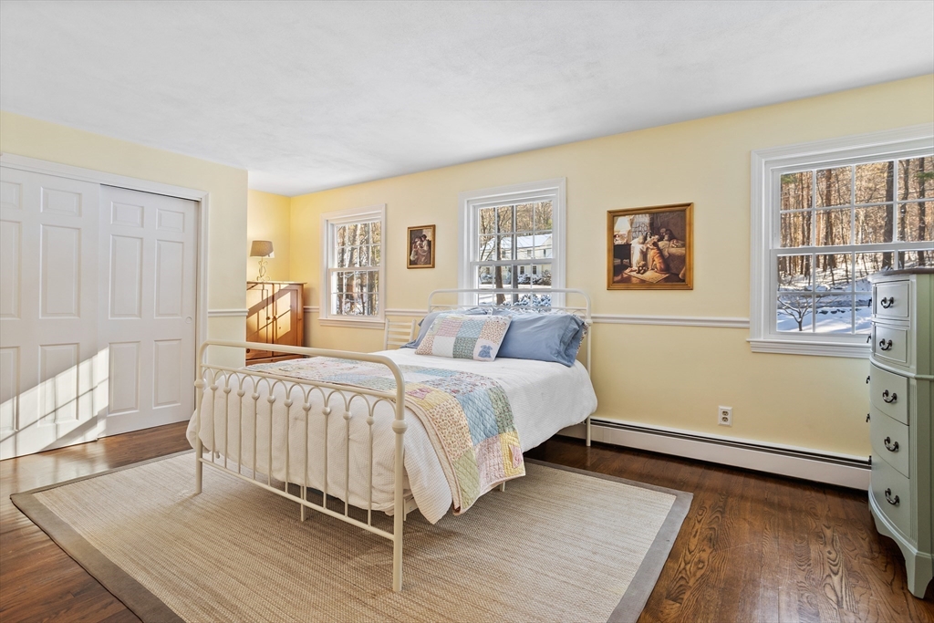 84 Vaughn Hill Road Bolton, MA 01740 - Photo 24 of 40 a bedroom with a bed and wooden floor