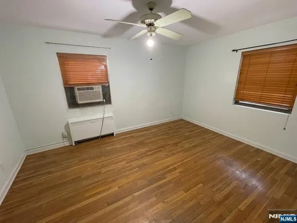 an empty room with windows and fan