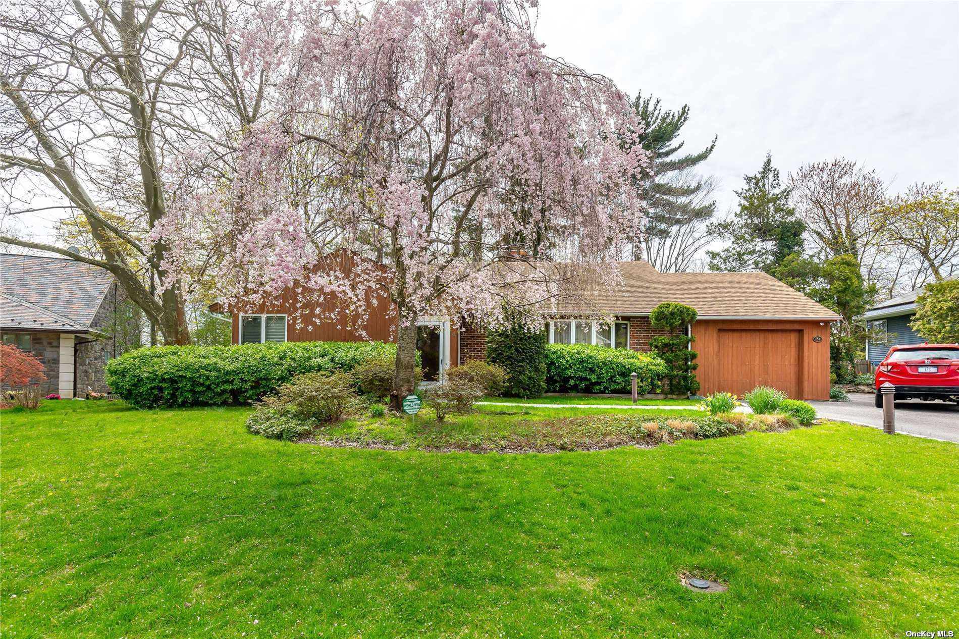 a front view of a house with a yard and trees