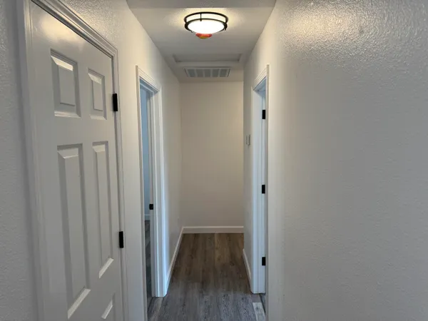a view of an empty room with wooden floor