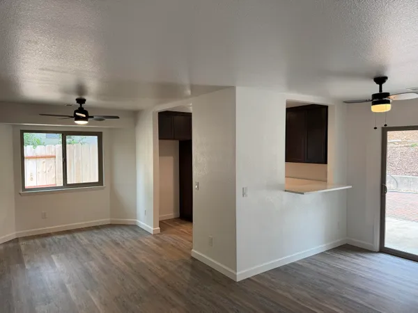 an empty room with wooden floor and windows