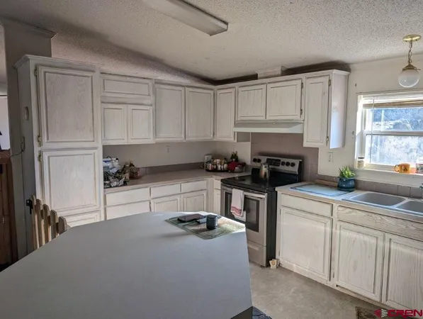 a kitchen with white cabinets and appliances