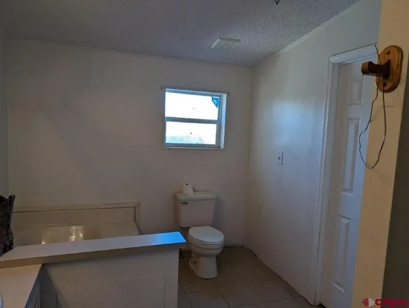 a bathroom with a toilet a sink and a window