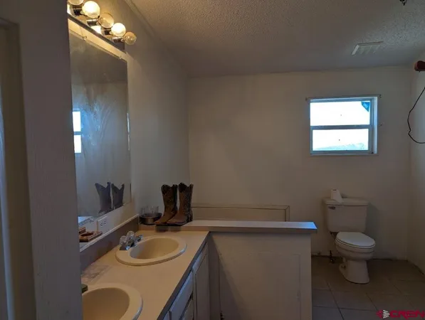 a bathroom with a granite countertop sink toilet and mirror