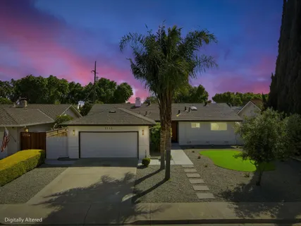 a front view of a house with a garden and yard