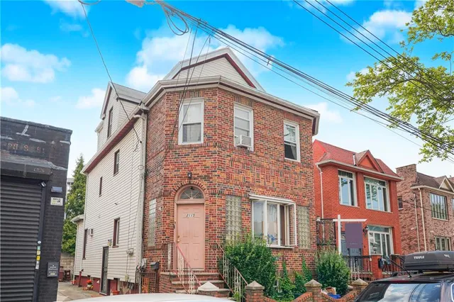 a front view of a residential apartment building with a yard