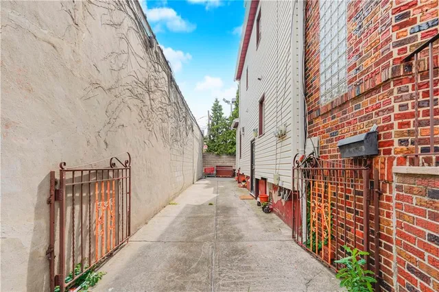 a view of a pathway with a house on a brick wall