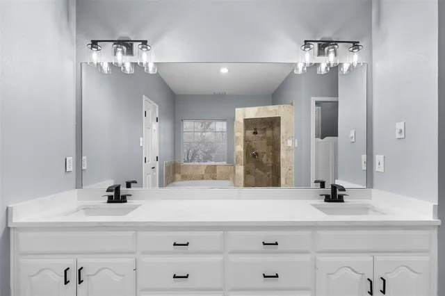a bathroom with double vanity sink and a mirror