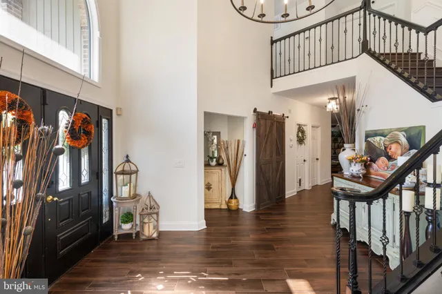 a view of a dining room and livingroom with furniture wooden floor a chandelier