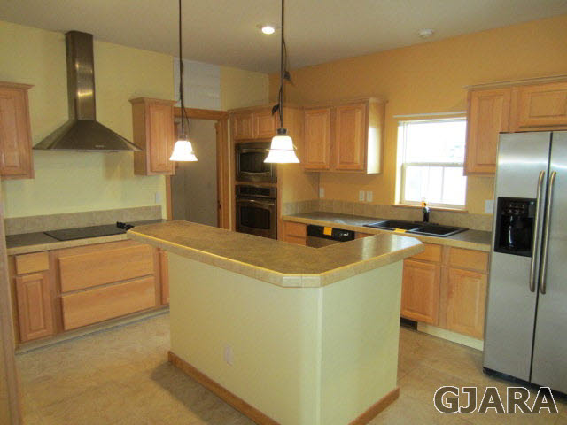 1441 18 Road Fruita, CO 81521 - Photo 3 of 10 a kitchen with kitchen island a counter top space a sink a refrigerator and a stove