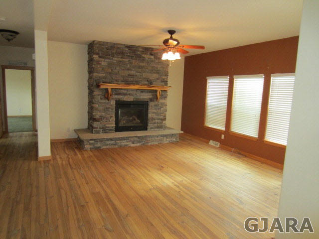 1441 18 Road Fruita, CO 81521 - Photo 5 of 10 an empty room with wooden floor fireplace and windows