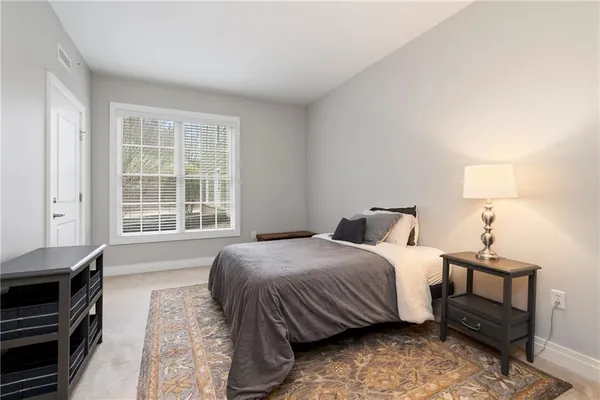 a bedroom with a bed and a dresser next to a window