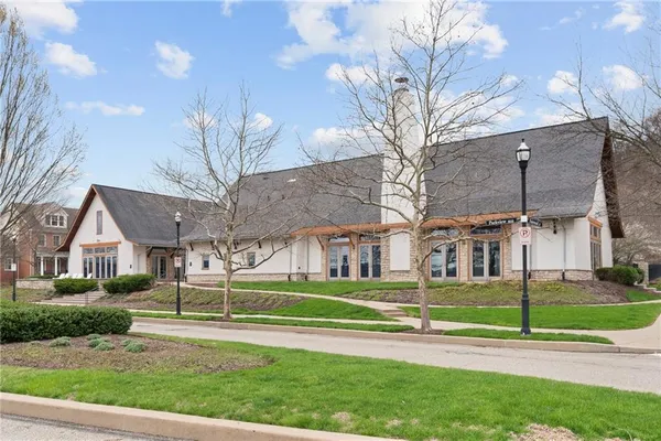 a view of a white house in a big yard with large trees