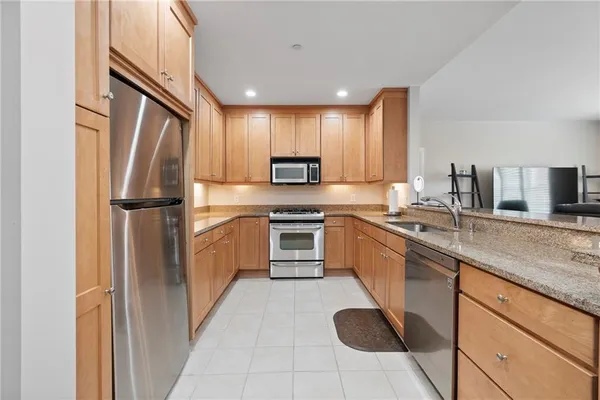 a kitchen with stainless steel appliances granite countertop a refrigerator sink and stove