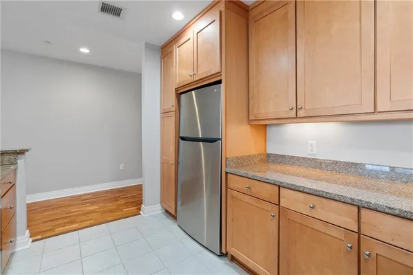 a kitchen with granite countertop cabinets and refrigerator