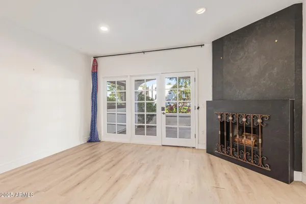 a view of an empty room with a window and a fireplace