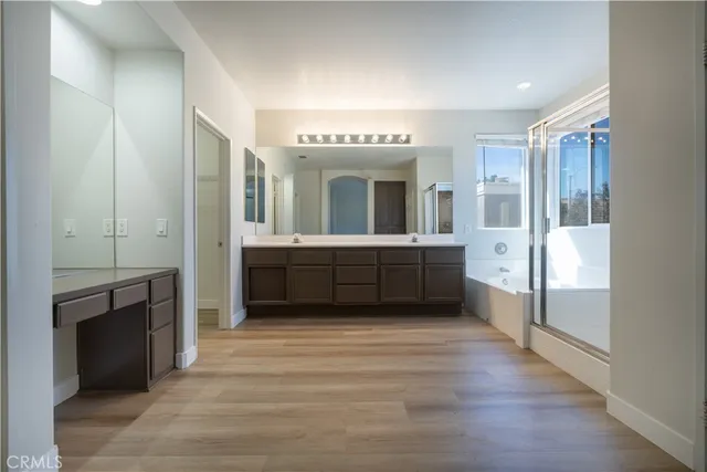 a view of a big room with wooden floor and windows