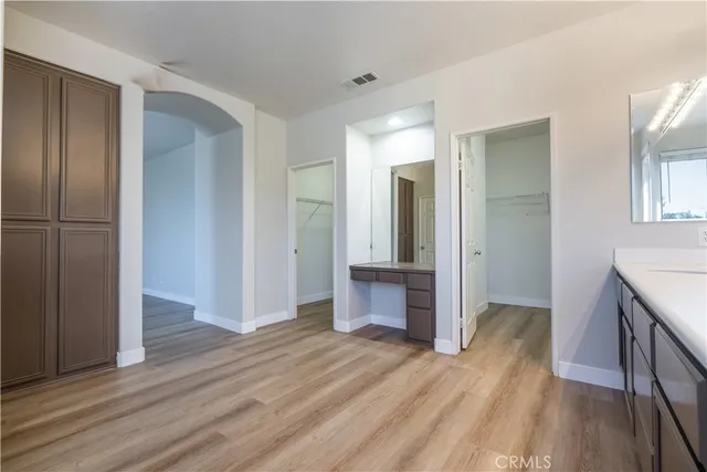 a view of kitchen with stainless steel appliances wooden floor and cabinets