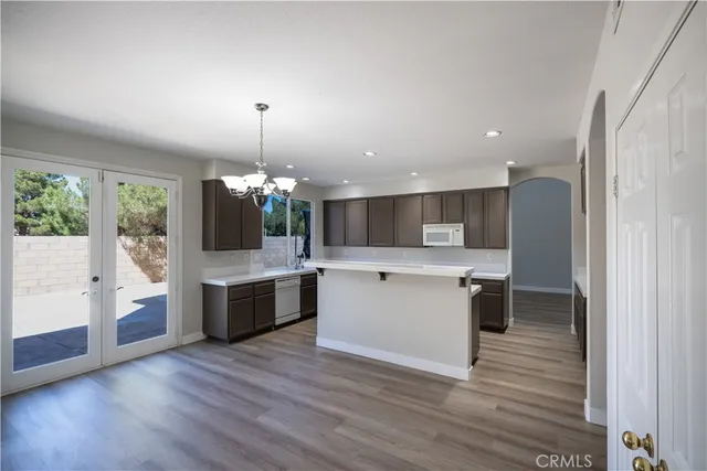 a kitchen with a refrigerator and a wooden floor