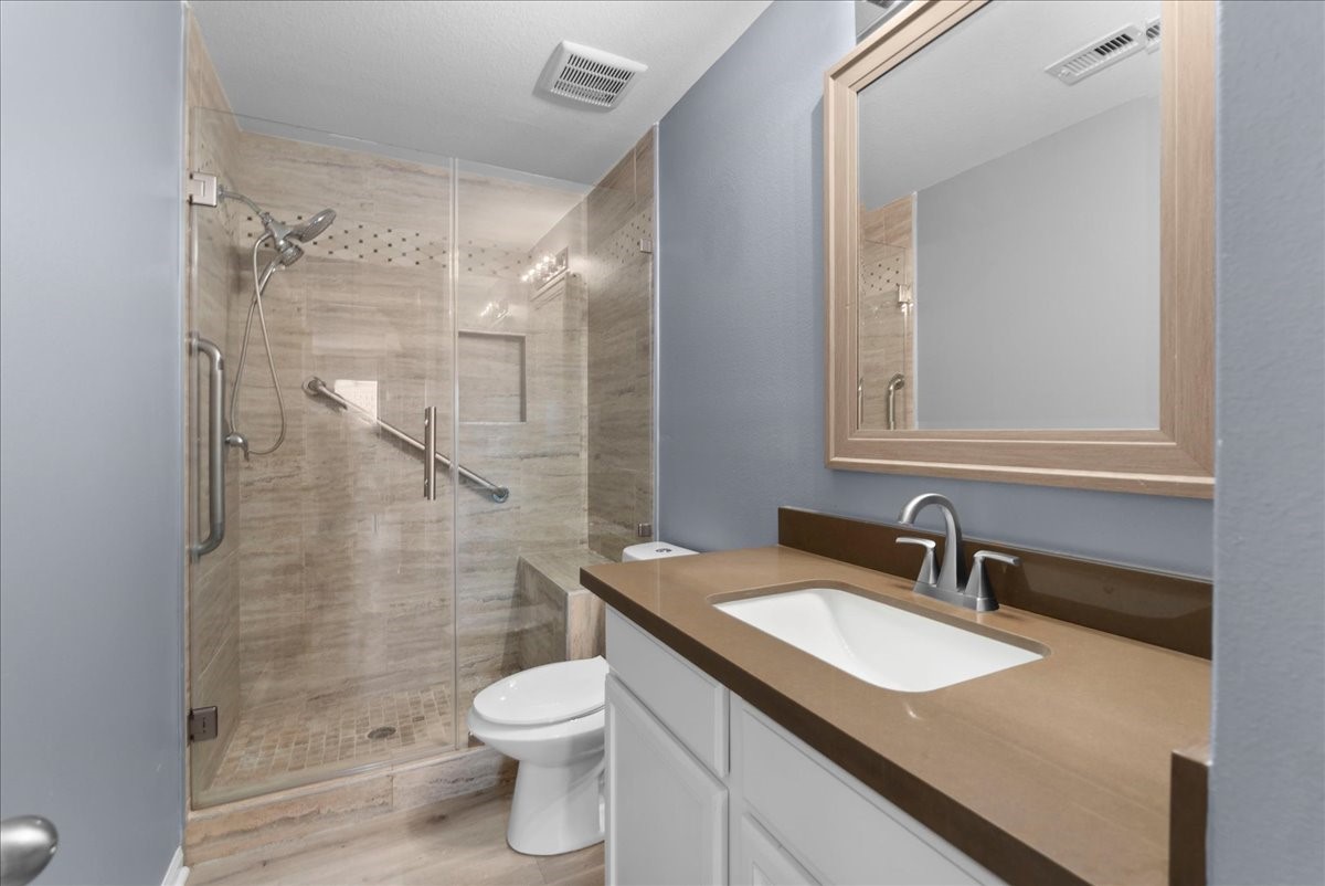5727 Treasure Cove Road Cove, TX 77523 - Photo 13 of 20 a bathroom with a granite countertop sink toilet and shower