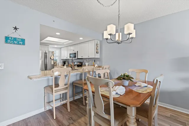 a view of a dining room with furniture a chandelier and wooden floor