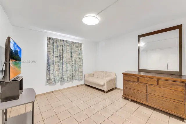 a living room with furniture a flat screen tv and a window