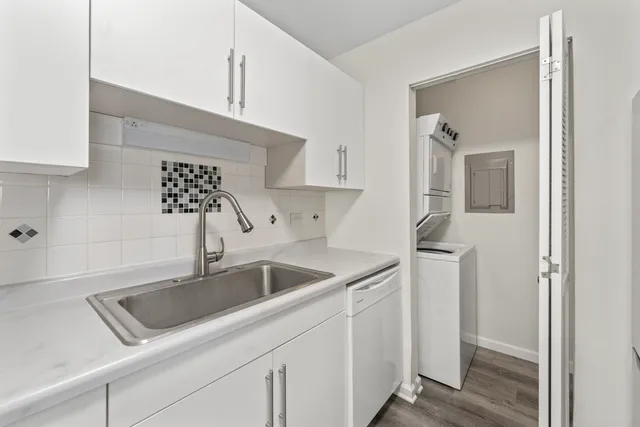 a kitchen with stainless steel appliances granite countertop a sink and a white stove next to a window